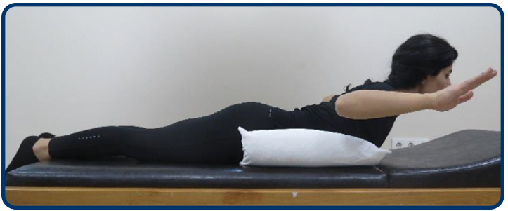 Karnınızın altına bir yastık koyarak yüzüstü uzanın. Dirseklerinizi 90 derece bükülü pozisyonda başınızı, kollarınızı ve omuzlarınızı yukarı doğru kaldırın. Bu pozisyonda 5 sn tutun ve gevşeyin.